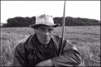 Analoge Fotografie SchwarzWeiß mit Leica M, Silber-Gelatine-Vergrößerung, Frankreich, Normandie, Schäfer auf einem Feld mit Zigarettenkippe